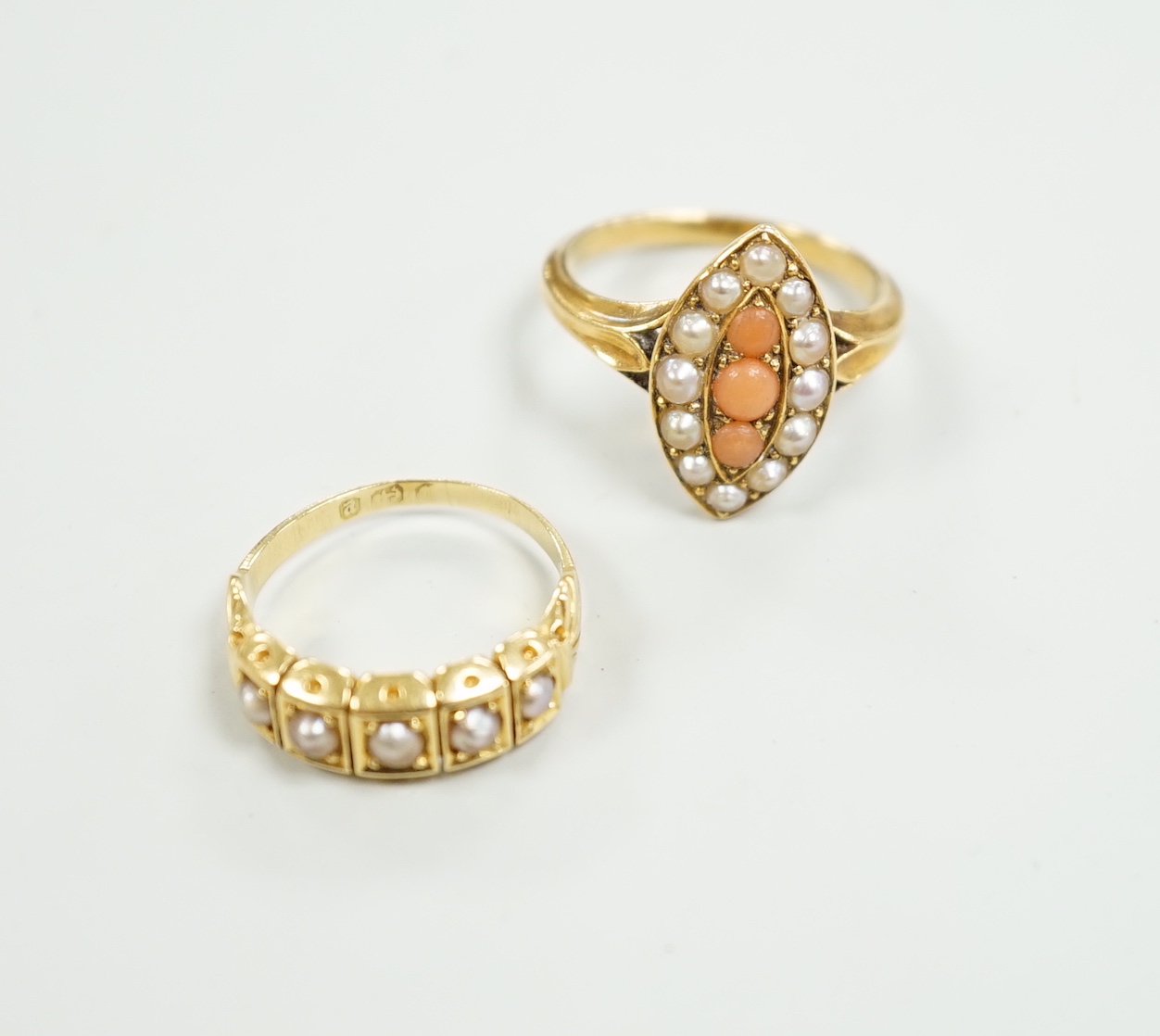 A late Victorian yellow metal, split pearl and coral set marquise shaped ring, size L and a similar yellow metal and split pearl set half hoop ring, gross weight 8 grams.